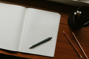An open notebook and a pen on a desk