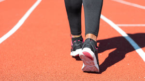 A person walking down the center lane of an outdoor running track